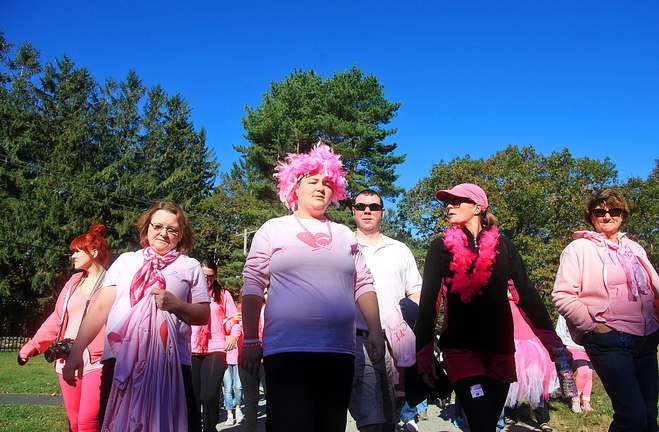 Jill Brady/Staff Photographer: Tracy Treubig of Portland, center, who is fighting breast cancer and is also 29 weeks pregnant, walks with team "Pink and Positive," made up of family and friends, as they walk to support the fight against breast cancer Sunday, October 20, 2013 at Fort Williams Park in Cape Elizabeth.