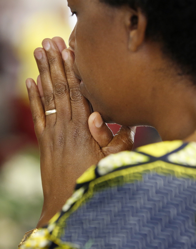 A woman prays at the church filled with “new Americans.”