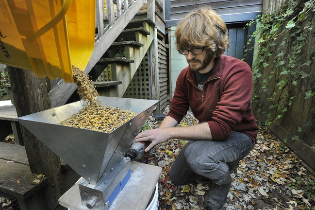 Craig Dilger grinds up freshly roasted barley that he will be using to brew his next batch of home brew.
