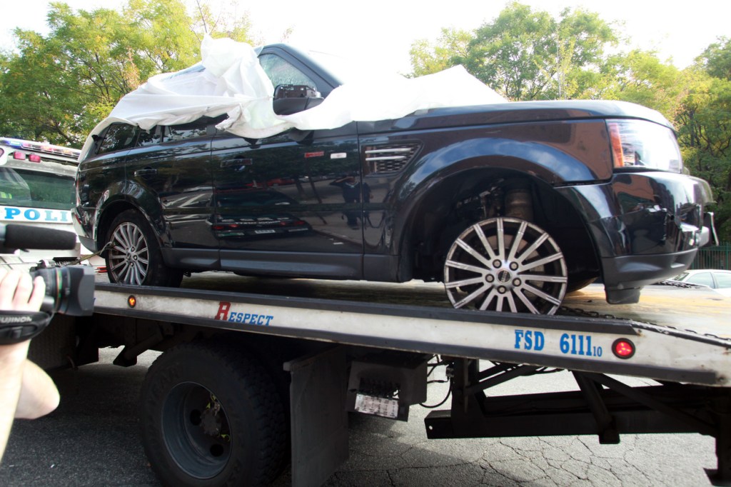In this Oct. 5, 2013 file photo, The Range Rover involved in the bikers attack is moved from the police precinct for further police investigation in New York. An off-duty New York Police Department undercover detective apparently seen on video pounding on an SUV during a melee with motorcyclists has been arrested, Tuesday, Oct. 8, 2013.