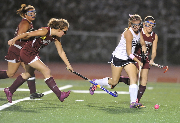 Haley Boydon of Yarmouth pushes the ball through the Freeport defense, including Abby Smith, right, in the first half of their Western Maine Conference field hockey game Tuesday at Yarmouth High.