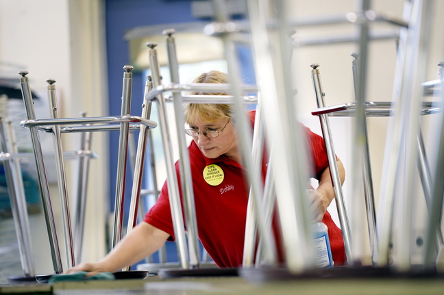 Debby Bean, custodian at Scarborough Middle School, cleans desks in a classroom after the students have gone home for the day Monday. “I would like the schools to stay safe and clean and keep the jobs local,” she says.