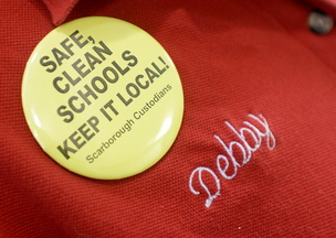 Bean wears a pin supporting Scarborough custodians as she cleans classrooms at Scarborough Middle School, where she has been night custodian for 12 years.