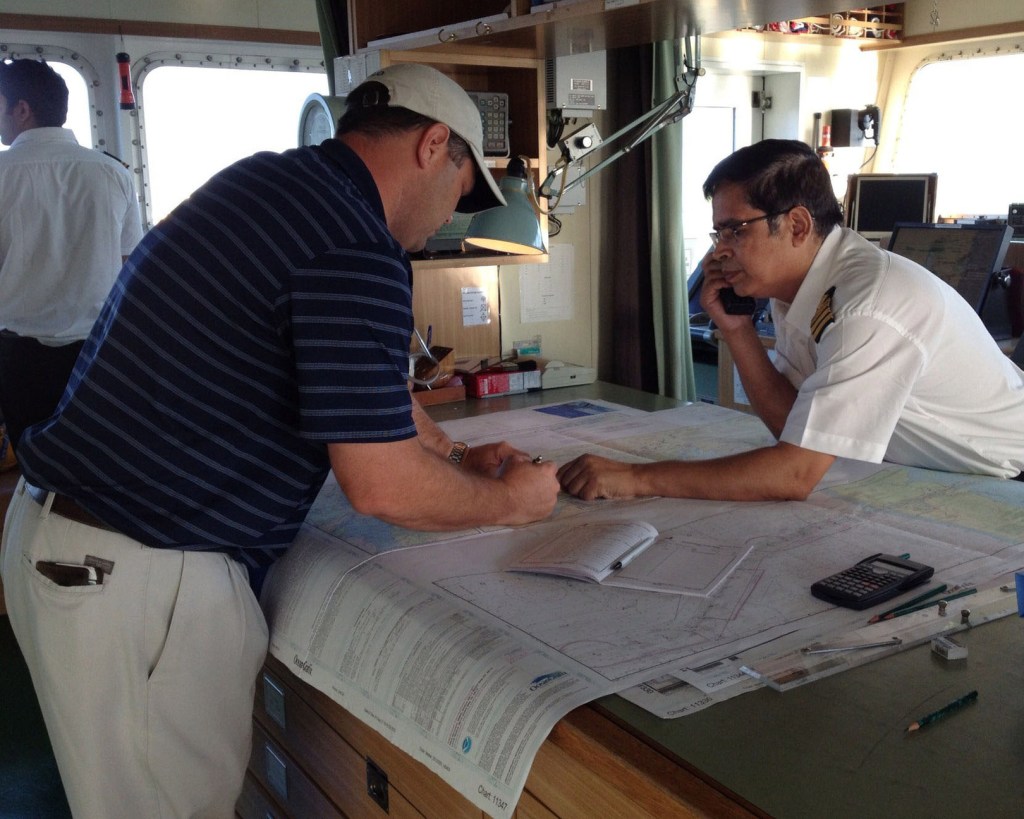 Mariners use a printed nautical chart aboard their ship.