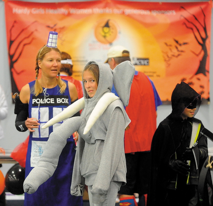 Alison Stabins, 11, center, dressed as an elephant, and her mother, Amy, dressed as Tardis from “Dr. Who,” await the start of the Freaky 5K Fun Run sponsored last Saturday by Hardy Girls Healthy Women at Colby College in Waterville. The event was organized to encourage girls to come up with creative and scary Halloween costumes instead of stereotypical or sexually overt ones.