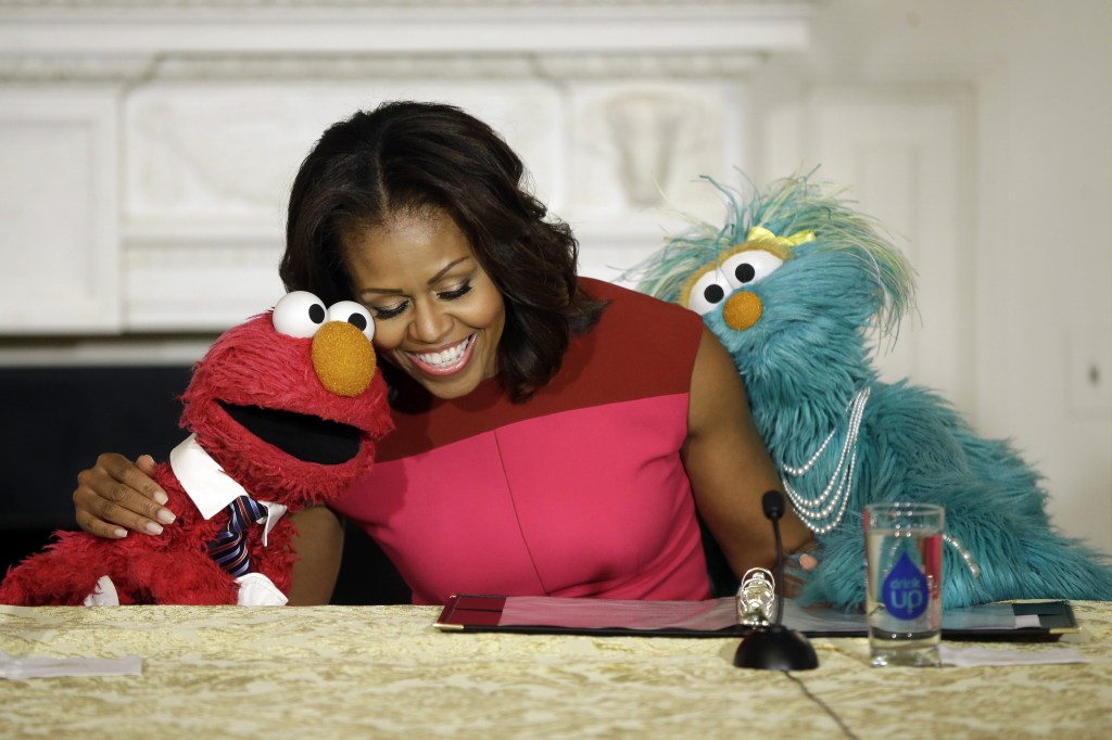 The Associated Press First lady Michelle Obama shares a hug with PBS Sesame Street’s characters Elmo, left, and Rosita as they help promote eating fresh fruits and vegetables to children at an event in the State Dining Room of the White House in Washington on Wednesday.