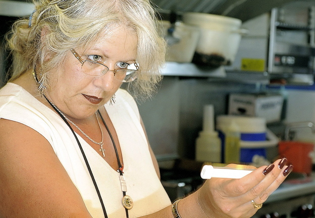 Michele Sturgeon checks the temperature of food at a Portland restaurant. A letter writer says the city should be ashamed for paying her to quit as health inspector.