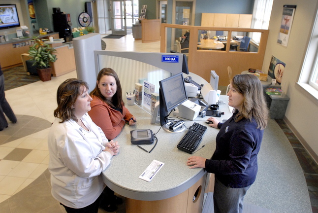 Teresa Webber and Jennifer Coyne conduct business with Heather Hatt in May 2009 at Town & Country Federal Credit Union in Scarborough.