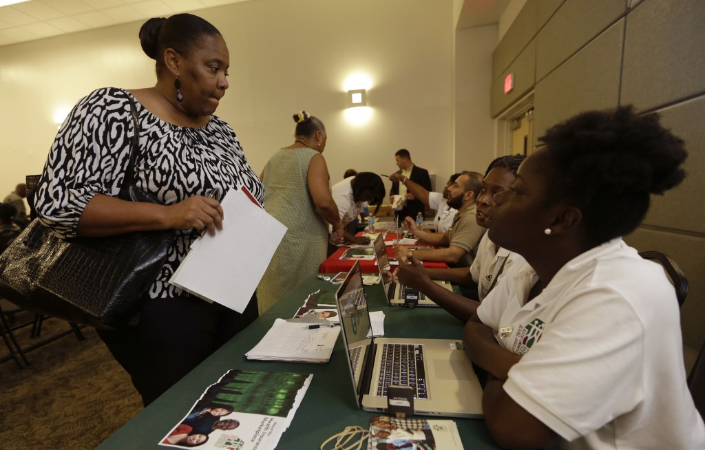 Velicia Martin talks with employees of the Jesse Trice Community Center about insurance options under President Obama’s health care law in Miami Gardens, Fla., Thursday. technology problems with a federal government website, many were unable to enroll online for the first few days of the program.