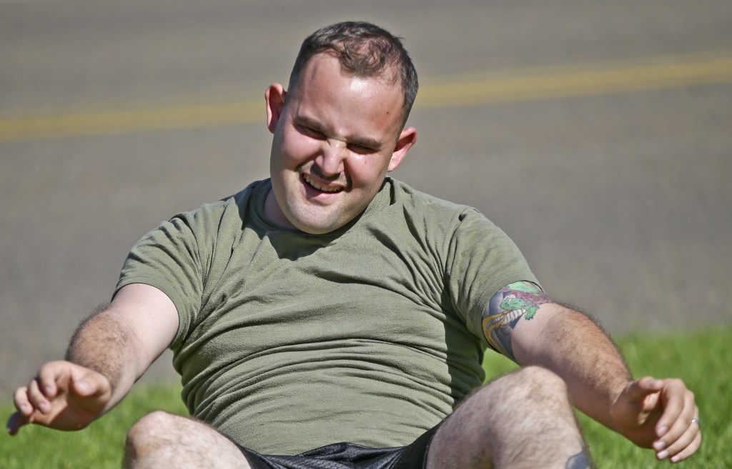 A service member who failed the so-called “tape test” struggles doing sit-ups during a workout where he hopes to improve his conditioning and avoid being dismissed from the military, at the Marine Corps Recruit Depot in San Diego. Marines have nicknamed the program for those who fail the test “pork chop platoon” or “doughnut brigade.”