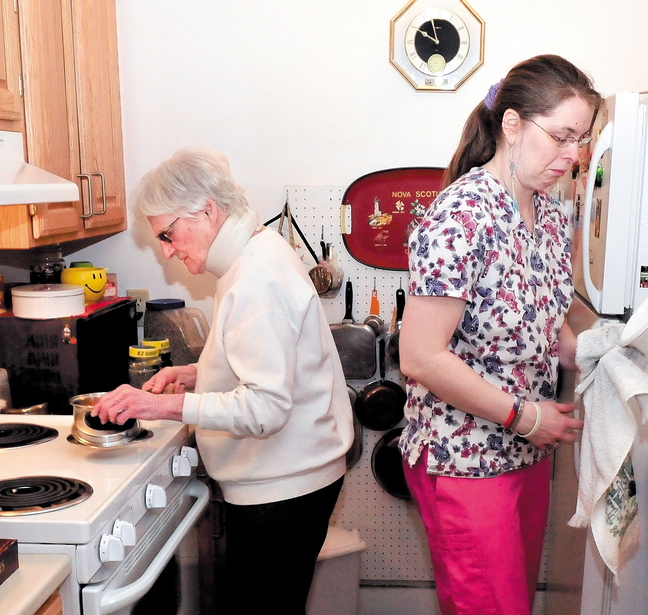 Seton Village resident Marie Rouleau, left, and personal support specialist Zandra Luce work in the kitchen preparing a meal March 25. Rouleau is on a waiting list for the Meals on Wheels program.