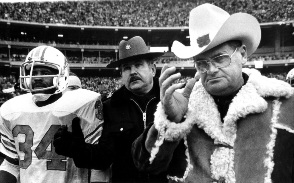In this Jan. 6, 1980, file photo, Houston Oilers Coach Bum Phillips and running back Earl Campbell leave field after the Oilers’ loss to the Pittsburgh Steelers in the AFC championship in Pittsburgh. Phillips, the folksy Texas football icon who coached the Oilers and New Orleans Saints, died Friday at age 90.