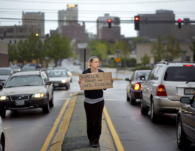 Alison Prior of Portland panhandles at the corner of Preble Street and Marginal Way in May. Prior is one of three residents suing the city over its ordinance barring people from standing in road medians.