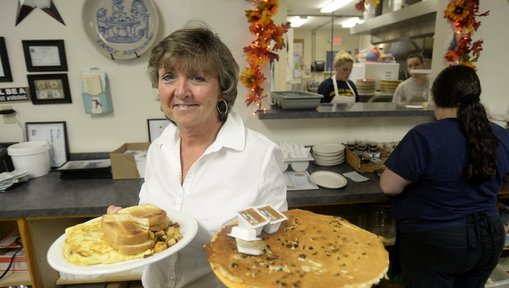 Server Sue Roberge shows off chocolate chip pancakes and a farmer’s omelette at Mayo’s Family Restaurant in Berwick.