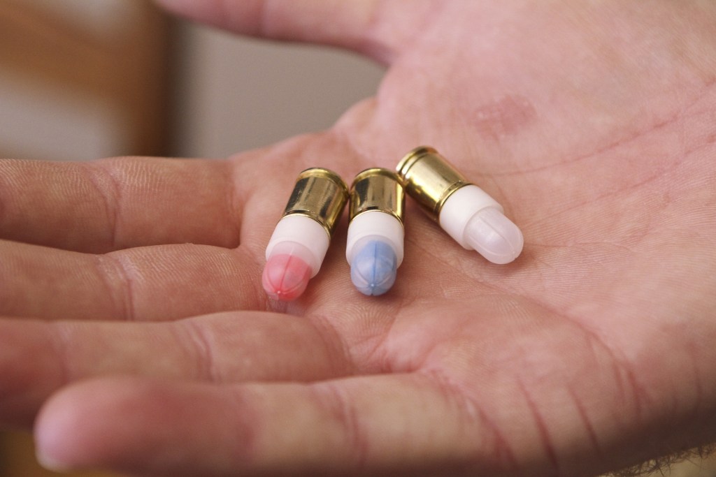 Firearms safety instructor Andrew Hyduchak displays nonlethal Simunition ammunition filled with powder that can mark targets with different colors at Prepare to Act firearms safety training facility, in Watertown, Conn. The facility is in a 2,000-square-foot structure set up to train gun owners in home invasion scenarios using the Simunition ammunition.