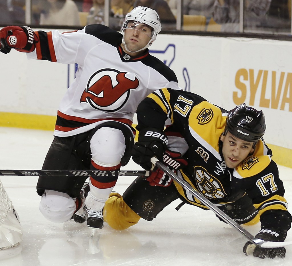New Jersey Devils’ Stephen Gionta, left, spills Boston Bruins’ Milan Lucic during the second period of Saturday’s game in Boston, won by the Devils on two late goals.