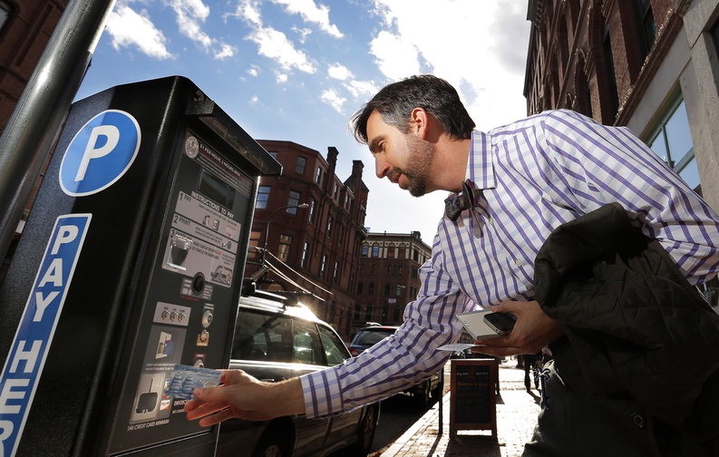 Jim Krebs of Portsmouth, N.H., who works in Portland at the University of New England, uses his credit card to pay for parking at one of the city’s new parking kiosks on Middle Street Friday afternoon. Krebs said he’s used to the kiosks because they’re everywhere in Portsmouth, and are much easier when he’s not carrying cash.