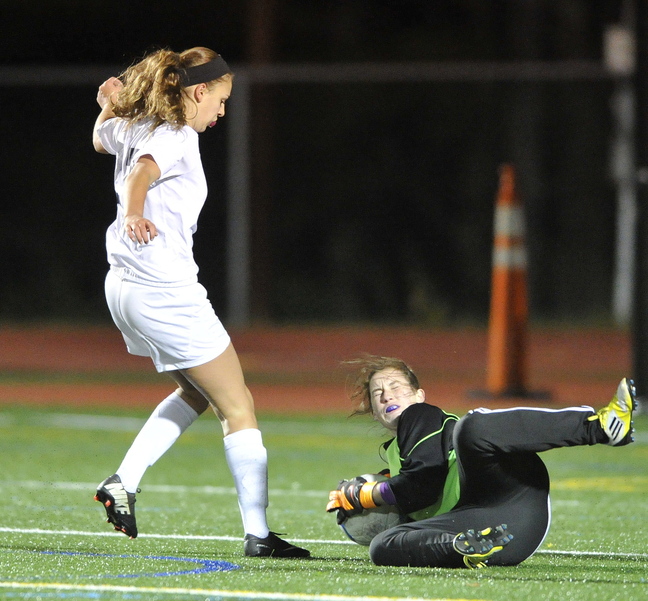 Freeport keeper Livvy Dimick sprawls to the turf to gather the ball in front of Yarmouth’s Katherine Clemmer. The Falcons will visit top-seeded Cape Elizabeth in the semifinals.