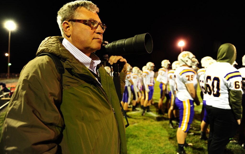 Self-employed photographer Michael Weaver works the sidelines of a high school football game in Jerseyville, Ill., on Friday night. It took him about a week and a half, but Weaver kept going back to the HealthCare.gov website until he opened an account and applied for a tax credit that will reduce his health care premiums. For the first time Sunday, the White House appealed for people to report their interactions with the exchange.
