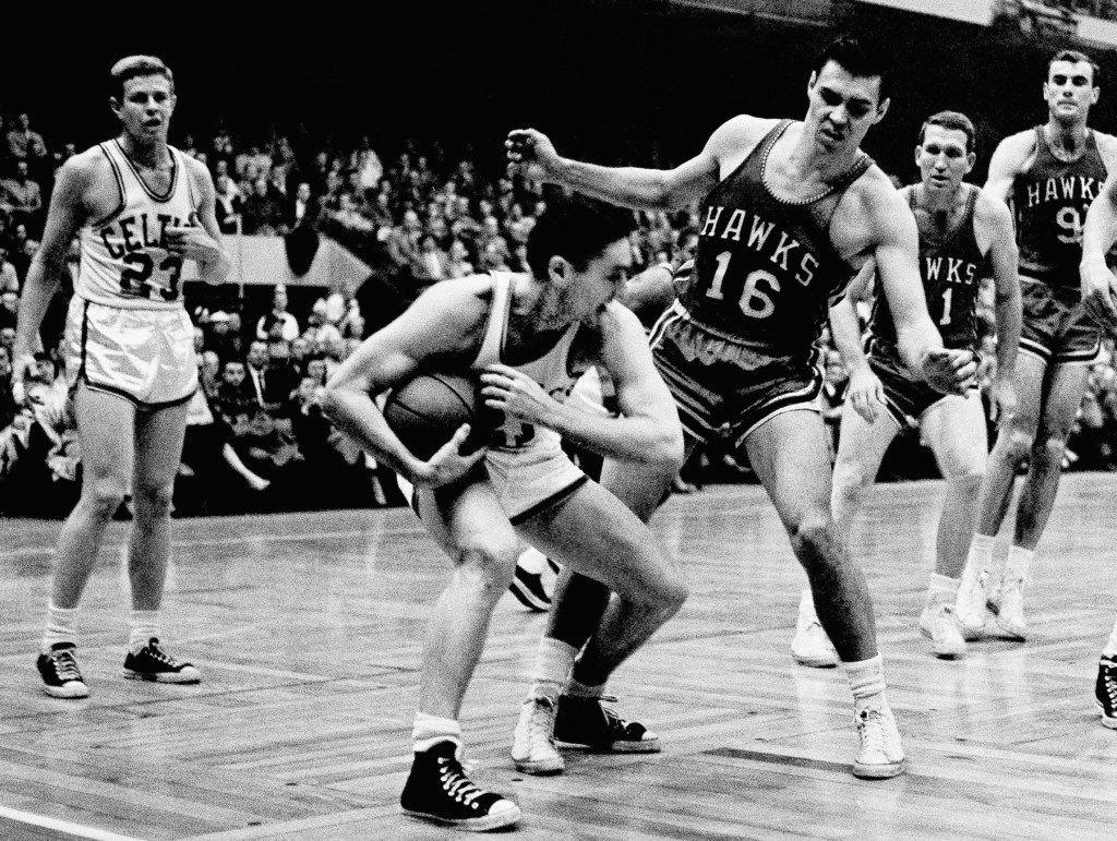 Boston Celtics’ Bill Sharman holds the ball as St. Louis Hawks’ Cliff Hagan defends, during an NBA Finals basketball game in Boston on March 30, 1958. Sharman, the Hall of Famer who won NBA titles as a player for the Boston Celtics and as a coach for the Los Angeles Lakers, has died. He was 87.
