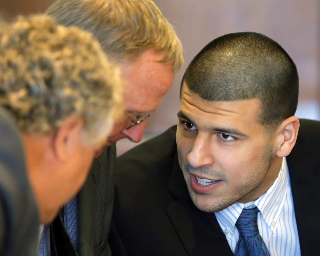 Aaron Hernandez, right, confers with defense attorneys Michael Fee, left, and Charles Rankin during the pretrial court hearing Wednesday.