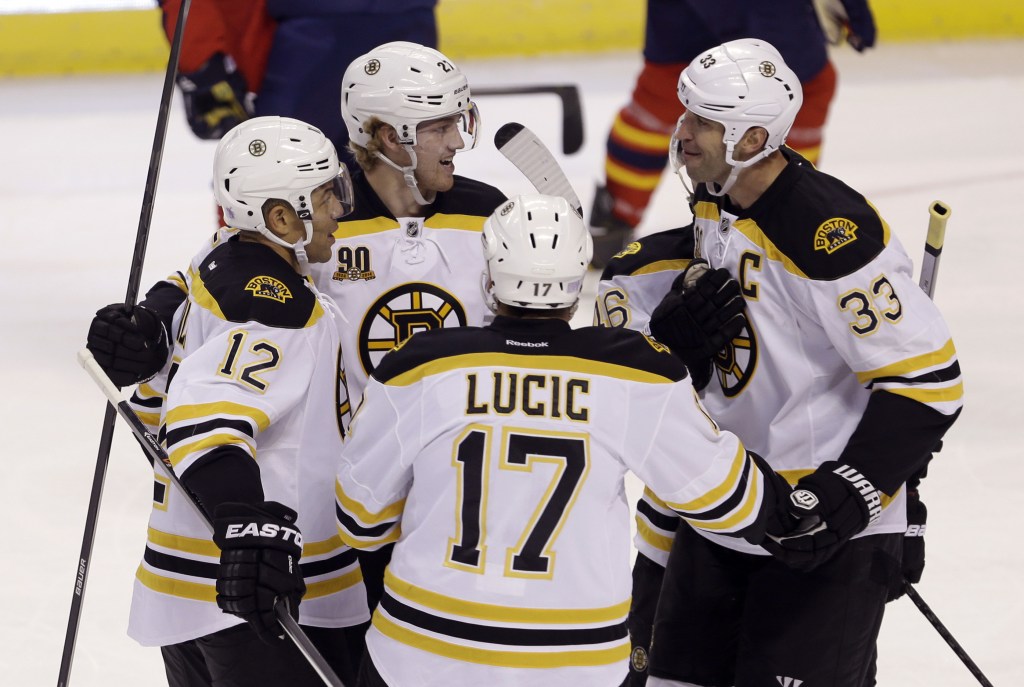 Boston Bruins defenseman Dougie Hamilton, 27, is congratulated by teammates Jarome Iginla, 12, Milan Lucic, 17, and Zdeno Chara, 33, after an early goal.