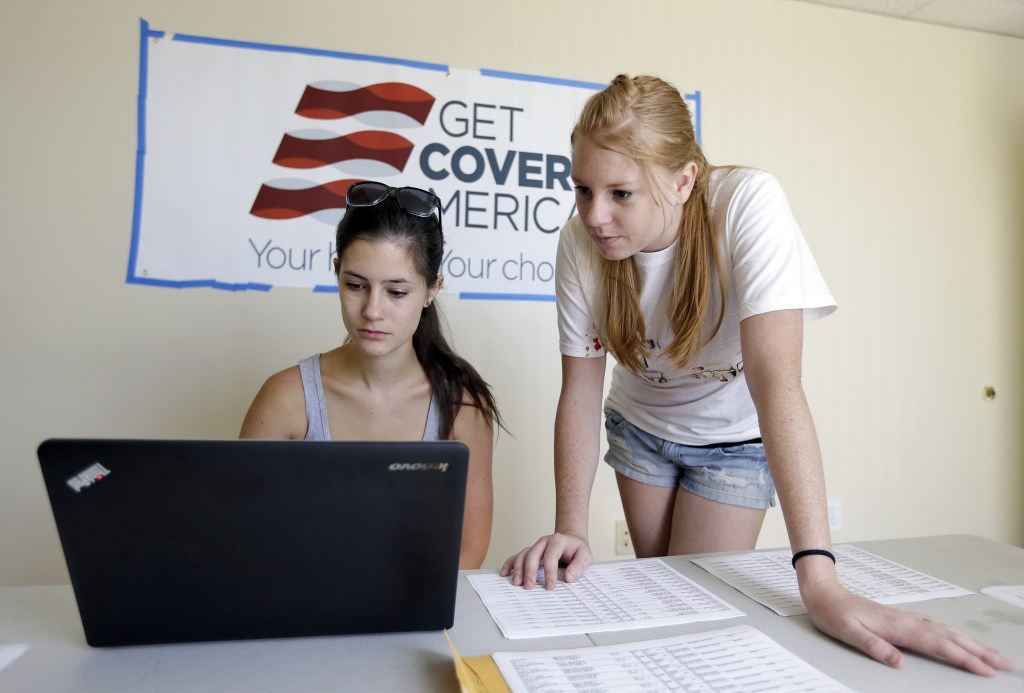 Ashley Hentze, left, of Lakeland, Fla., gets help signing up for health care from Kristen Nash, a volunteer with Enroll America, a private, non-profit organization running a grassroots campaign to encourage people to sign up for health care, Tuesday, Oct. 1, 2013. On the day consumers start perusing newly launched federal online health exchanges, Republican governors who oppose President Barack Obama’s insurance overhaul are mostly sitting on their hands. But the law is going into effect without them.