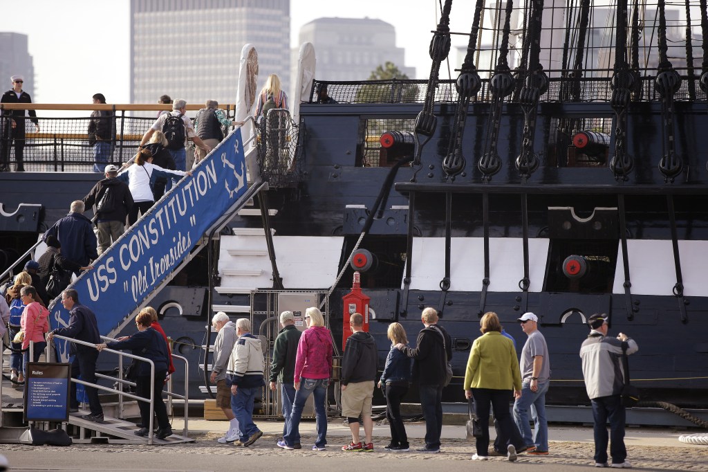 Visitors to the USS Constitution, the oldest ship in the U.S. Navy, line up to walk up the gang plank for a tour in Boston on Thursday. Federal memorials and National Park Service sites opened, and thousands of furloughed federal workers returned to work Thursday after 16 days off the job due to the partial government shutdown.