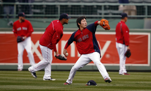 Boston Red Sox’s Koji Uehara throws with teammates before Game 1 of baseball’s World Series against the St. Louis Cardinals Wednesday, Oct. 23, 2013, in Boston.