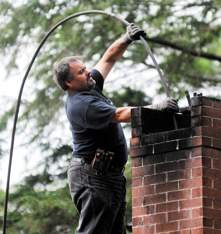Dave Pelletier of Downeast Chimney sweeps a flue on a home in Litchfield this week.