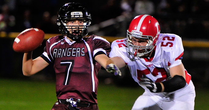 Greely quarterback Matt Pisini looks for a receiver as Alex Neill of Cony closes in during their Class B football game Friday night in Cumberland. Pisini threw two touchdown passes and rushed for two scores in Greely’s 35-21 upset victory.