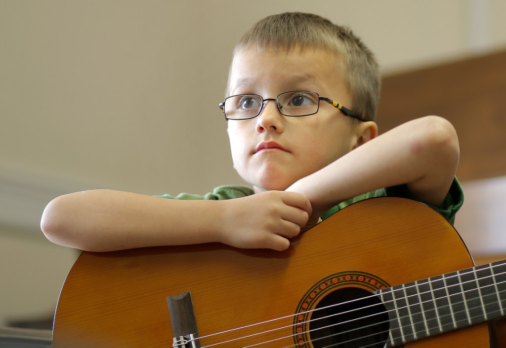 Michael Madden, 5, listens to teacher guitar teacher Don Pride while taking a class at the Portland Conservatory of Music on Tuesday.