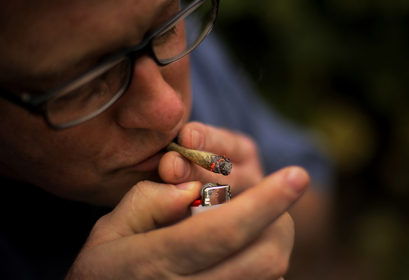 Crash Barry, a writer from Oxford County who grows marijuana for medicinal use, lights a marijuana cigarette in Portland last week.