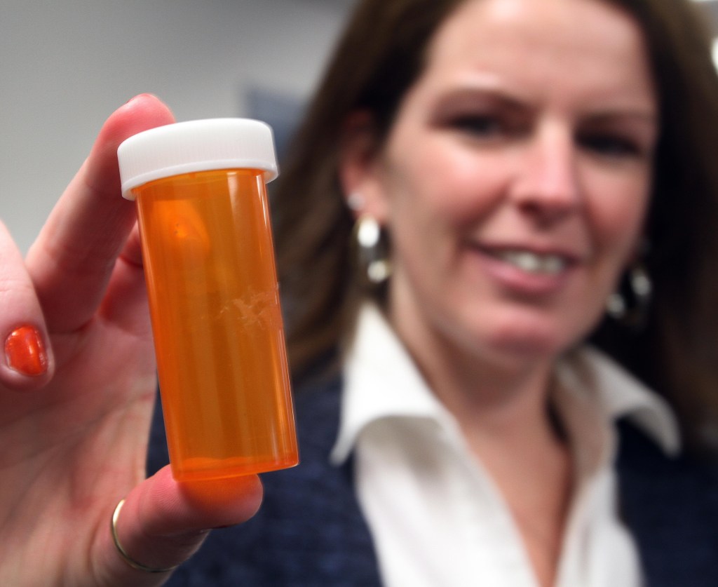 Novelty pill bottles like this one displayed by Celeste Clark, director of the Raymond (N.H.) Coalition for Youth, will no longer be used as promotional items by an online firm.