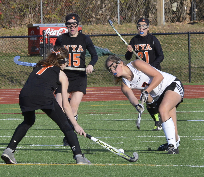 John Patriquin/StaffPhotographer Lisbon’s Molly Nicholson hits the ball past NYA’s Charlotte Eisenberg as North Yarmouth Academy and Lisbon play for the Western Class C field hockey championship at Thornton Academy in Saco. NYA won the game, 2-1.