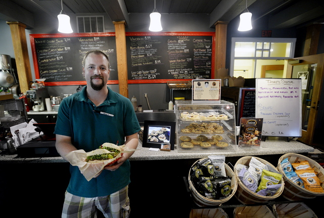 Mark Claussen of Saco Island Deli in Saco shows off a “Mainah,” one of the deli’s specialty sandwiches.