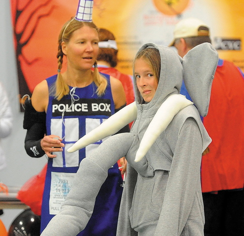 Alison Stabins, 11, center, dressed as an elephant, and her mother, Amy, dressed as Tardis from Dr. Who, wait for the start of the Freaky 5K Fun Run organized by Hardy Girls Healthy Women on Saturday at Colby College.