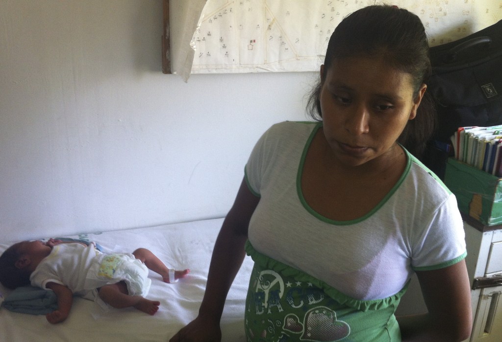 Irma Lopez stands near her son Salvador at a clinic in Jalapa de Diaz, Mexico. A nurse had refused to let Lopez enter the clinic a few days earlier, forcing her to give birth on the lawn.