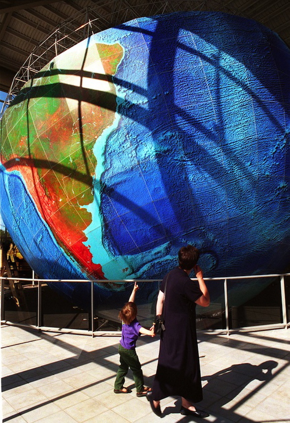 A boy and his mother enjoy the world-renowned 1:1,000,000-scale globe, which rotates on its axis and duplicates the earth’s movement at DeLorme in Yarmouth. The map company confirmed Monday that it has laid off 10 of its 85 workers as part of its efforts to shift to digital products and away from traditional mapping services.