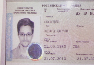 Former NSA contractor and fugitive Edward Snowden, shown in his new refugee documents, is adjusting to Russia, say four Americans who visited him Wednesday night. Snowden’s father has also arrived to visit his son.