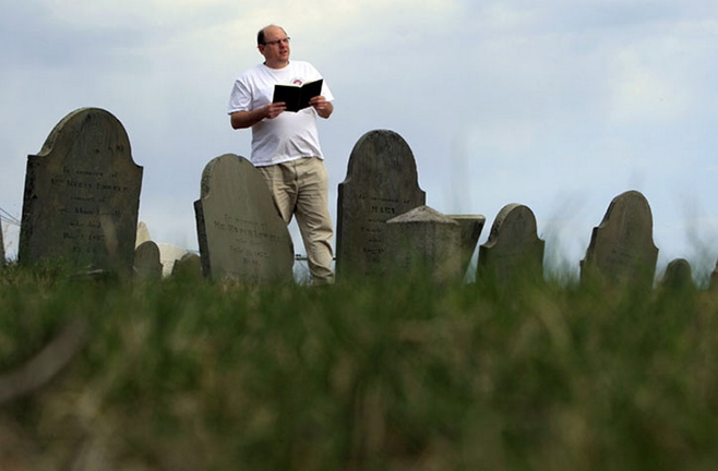 Walter Skold of Freeport reads a Henry Wadsworth Longfellow poem in Portland’s Eastern Cemetery in this April 2010 photo.