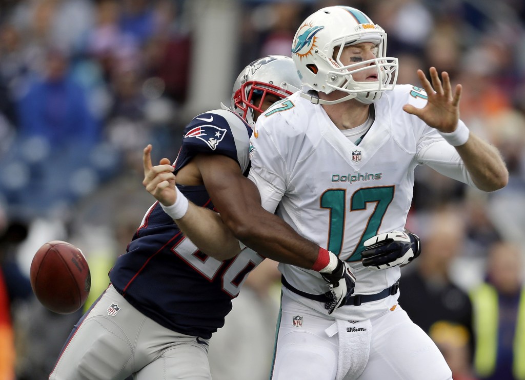 New England Patriots defensive back Logan Ryan, left, strips the ball from Dolphins quarterback Ryan Tannehill in the second half Sunday at Foxborough, Mass.