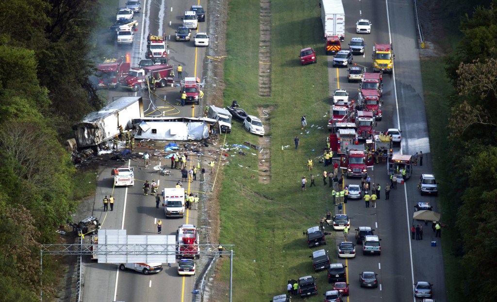 In this aerial photo, emergency workers respond to a crash involving a passenger bus, a tractor-trailer and an SUV near Dandridge, Tenn., on Wednesday. Authorities said the bus, carrying members of a North Carolina church group, veered across the highway median and crashed into the other vehicles in a fiery wreck that killed eight people.