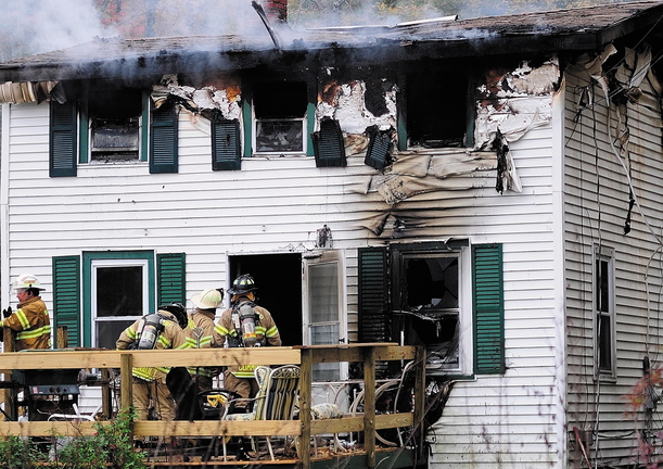 Staff photo by Joe Phelan Firefighters work to put out a house fire at 119 Granite Hill Road in Manchester on Saturday. One man died in the blaze.