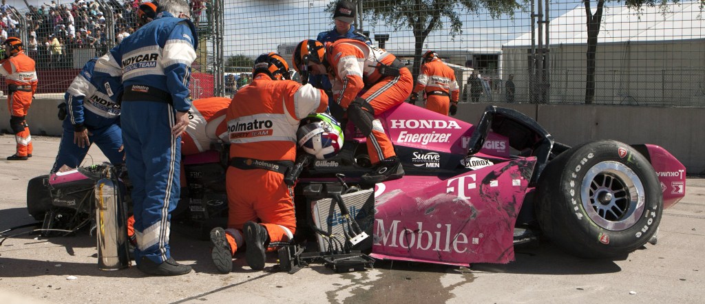Safety team members work to remove Dario Franchitti, of Scotland, from his car after a crash during the second IndyCar Grand Prix of Houston auto race, Sunday, Oct. 6, 2013, in Houston.