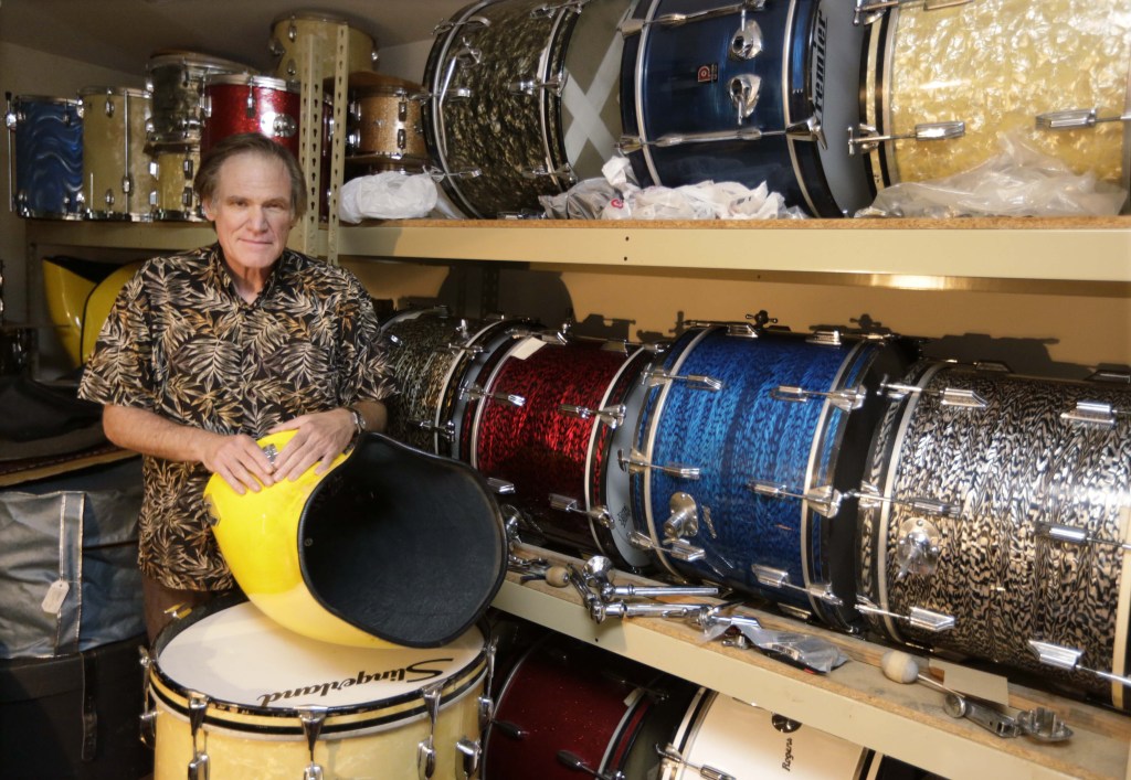 James Glay poses with his collection of vintage drums in Arlington Heights, Ill. When he was laid off from his sales job he joined a growing number of older people and created his own.