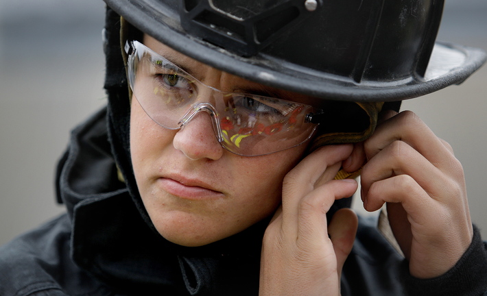 Silas Corman, 17, a Portland High senior, adjusts his firefighting helmet before entering a building on Elm Street in Portland with other students from Portland and Deering high schools on Saturday. The exercise was part of a course offered by the schools in conjunction with the Portland Fire Department.