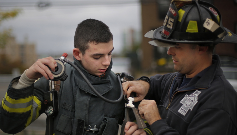 Owen Sprague, 15, a Deering High sophomore, gets some help with his regulator from Portland firefighter Wendell Howard on Saturday during the class.