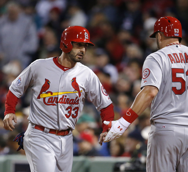 St. Louis Cardinals' Daniel Descalso (33) is congratulated by Matt Adams after scoring against the Boston Red Sox during the seventh inning of Game 2 of baseball's World Series Thursday, Oct. 24, 2013, in Boston. (AP Photo/Elise Amendola)