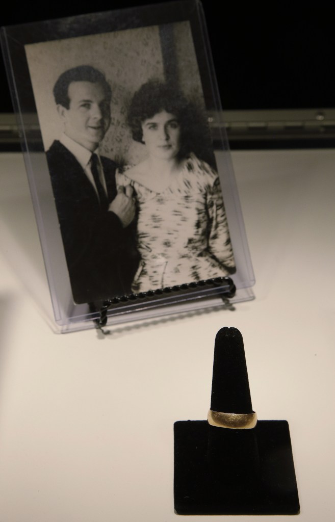 Lee Harvey Oswald’s wedding ring is displayed in front of a photo of Lee Harvey Oswald and his wife, Marina Oswald.